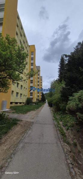 Apartment building and sidewalk surrounded by greenery on Moskovská Street in Banská Bystrica - Fončorda.