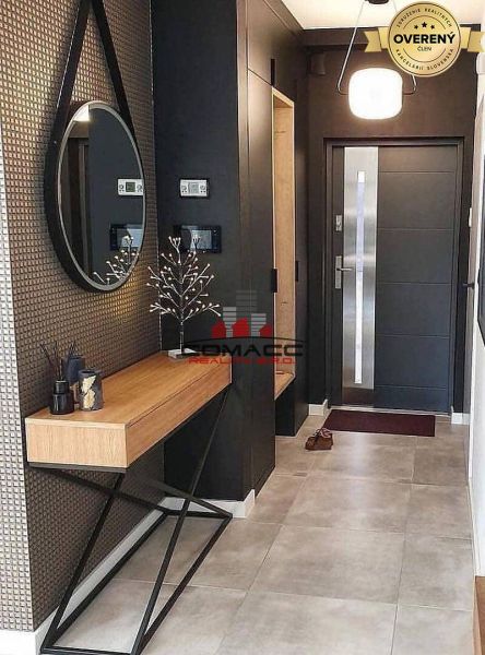 In the family house, there is a counter with decoration, a mirror, and an entrance door.