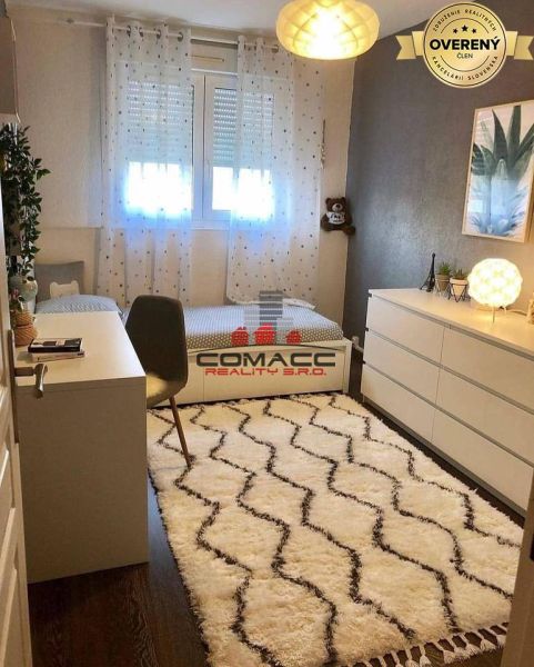 Children's room in a family house with a white carpet and a wooden decor floor.