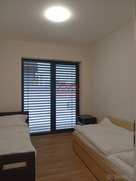 Bedroom with two beds and a wooden decor floor in a family house.