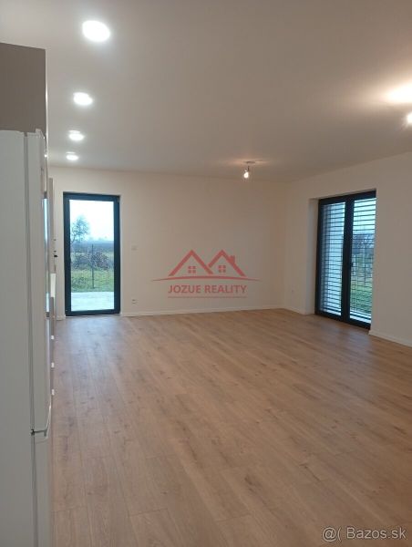 Spacious living room with wood-patterned flooring in a family house.