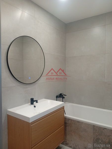 A bathroom with a round mirror and a wooden cabinet in a family house.