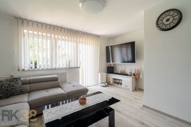 Living room in a family house with a sofa and television, floor with wooden decor.