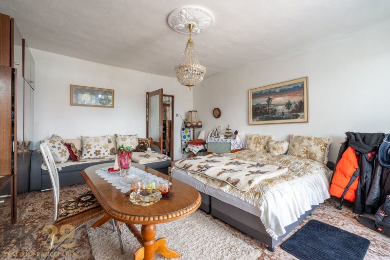 Living room in a family house with a sofa, table, chandelier, and decorative pillows.