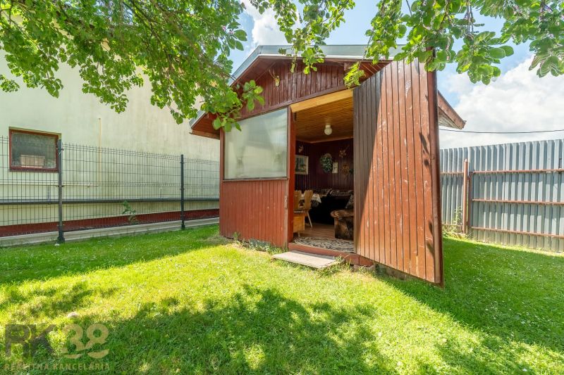 A wooden gazebo on a grassy plot near a family house on Športová Street in Hozelci.
