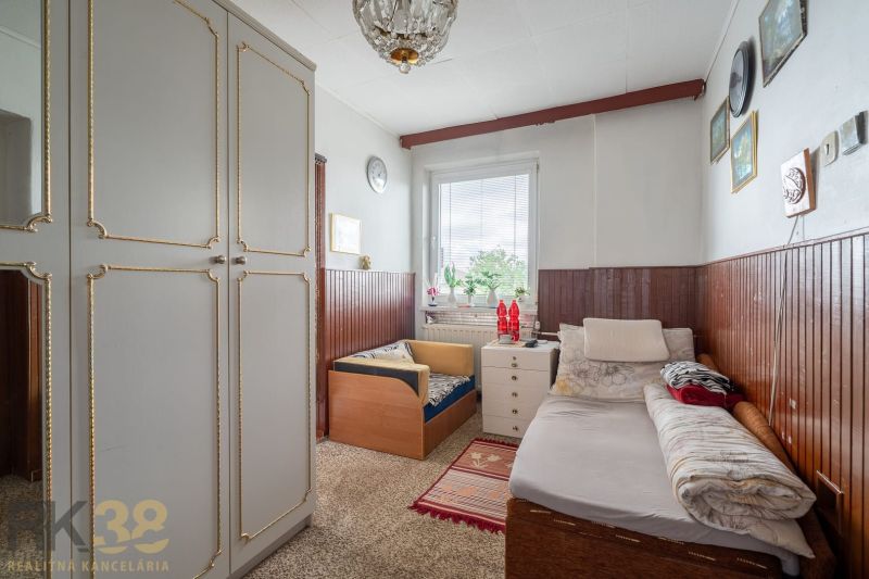 A room in a family house with a bed, storage space, and wall decorations.
