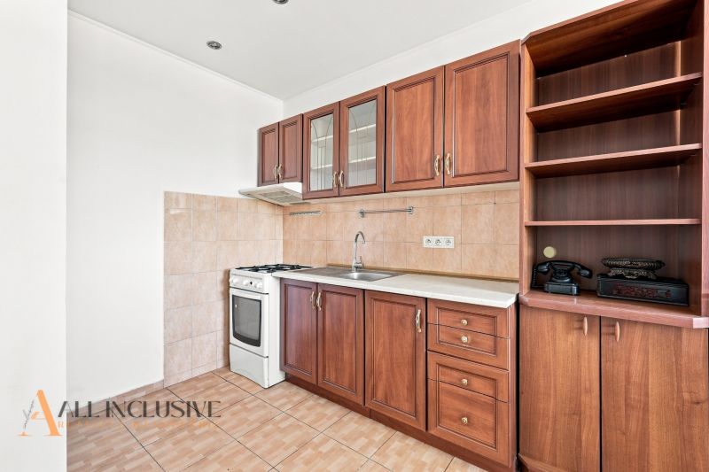 A kitchen in a 2-room apartment with a kitchen unit and a floor with a wooden decor.