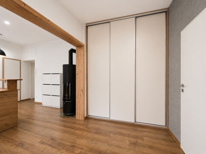 Interior of a 2-room apartment with a wooden decor floor and a built-in wardrobe.