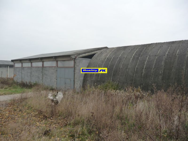 Warehouses and halls in Trnava with concrete structures and metal doors in a neglected environment.