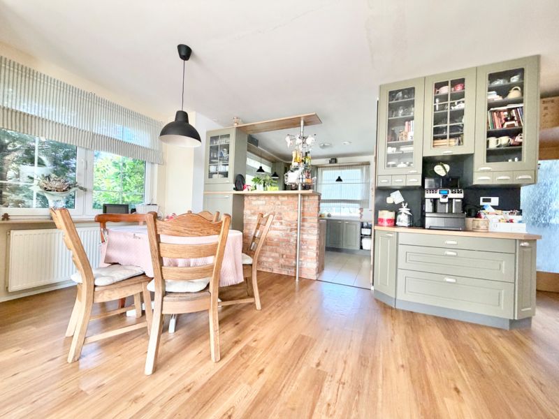 A kitchen in a family house with a wooden decor floor and wooden furniture.