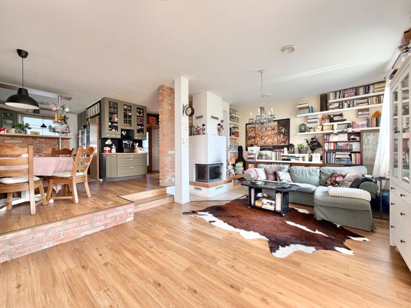 Interior of a family house with a kitchen, wood-decor flooring, and comfortable seating.