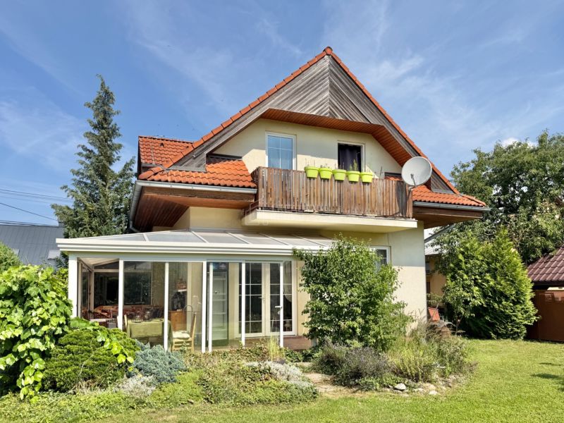 A family house in Mojš with a balcony, a glassed-in veranda, and a well-maintained garden.