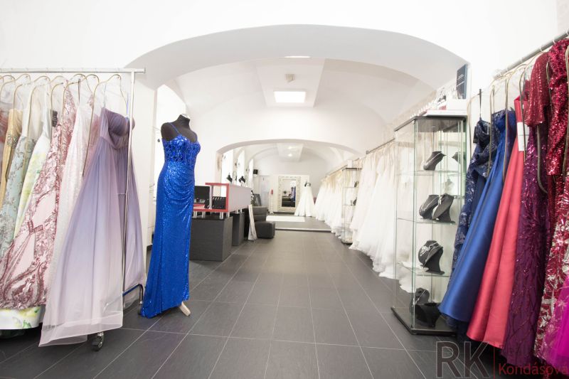Commercial premises with displayed evening and wedding dresses, wooden decor flooring.