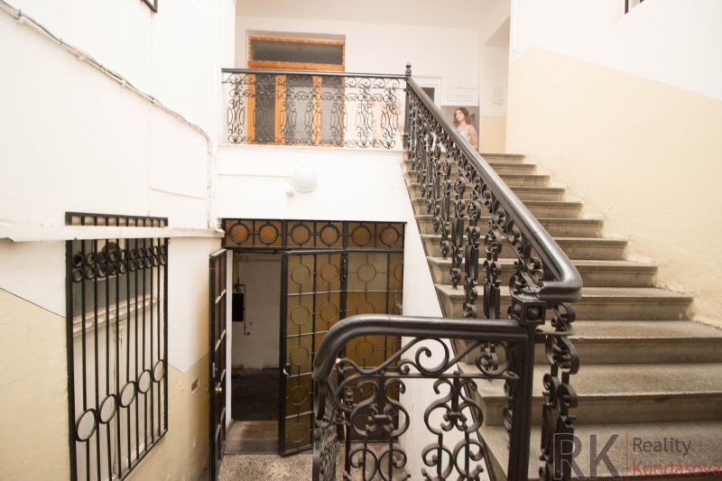 A staircase with a metal railing in the premises of a commercial space.