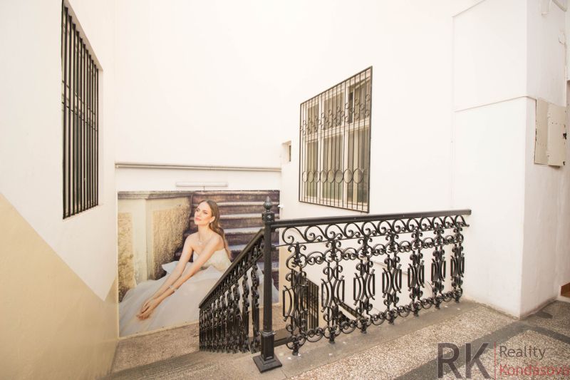 A staircase with a metal railing and an advertisement on the wall in commercial premises.