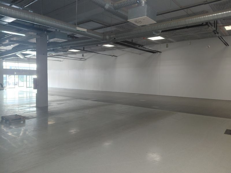 Spacious commercial spaces with concrete flooring and exposed pipes on the ceiling.