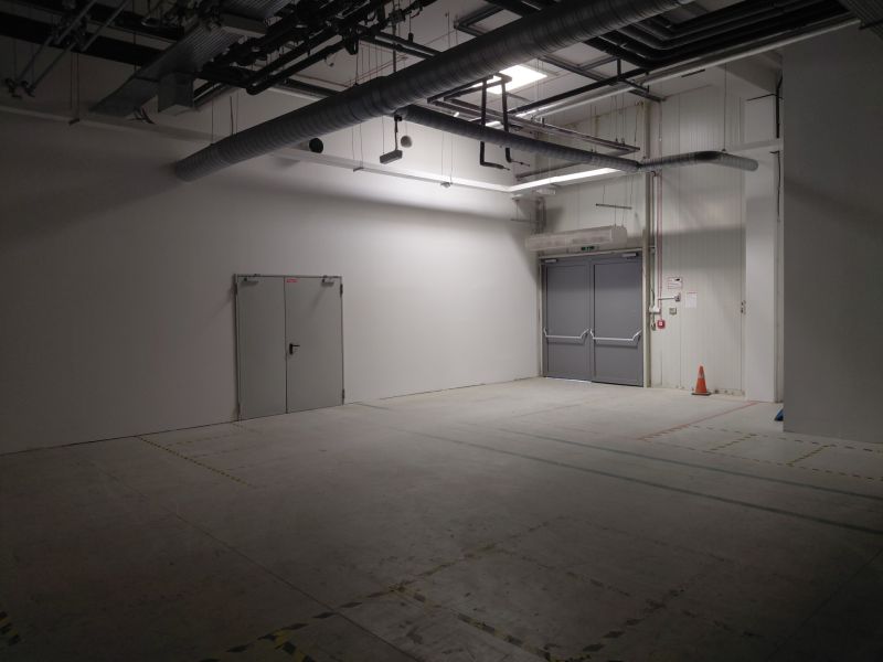 Empty commercial spaces with industrial equipment, white walls, and lights.