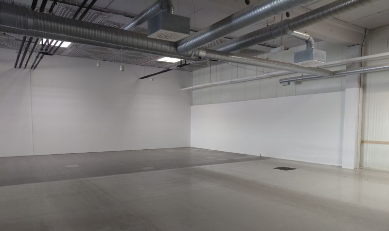 Empty commercial spaces with suspended ceilings and ventilation.