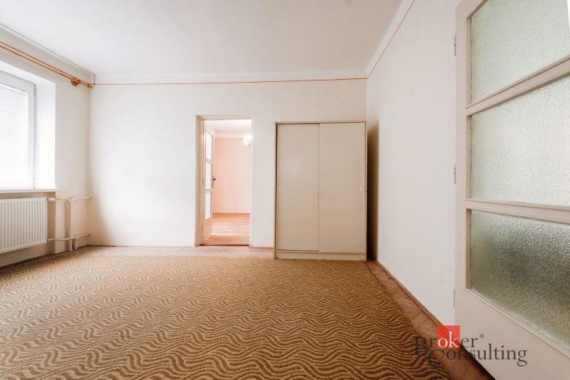 A room in a family house with a carpet and a drawer cabinet.