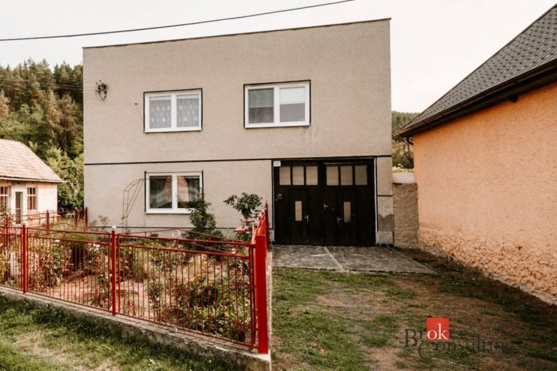 A family house in Radzovce with an entrance gate, a swing, and a paved terrace.