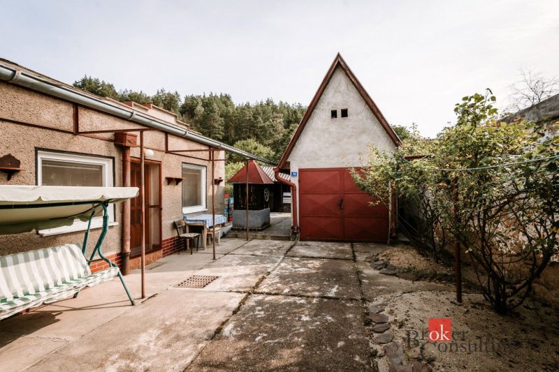 A family house in Radzovce with a yard, a chair, a swing, and a roof with a wooden decor.