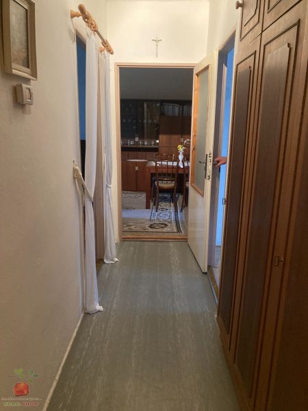 A hallway in a 3-room apartment with practical storage space and a view into the dining room.