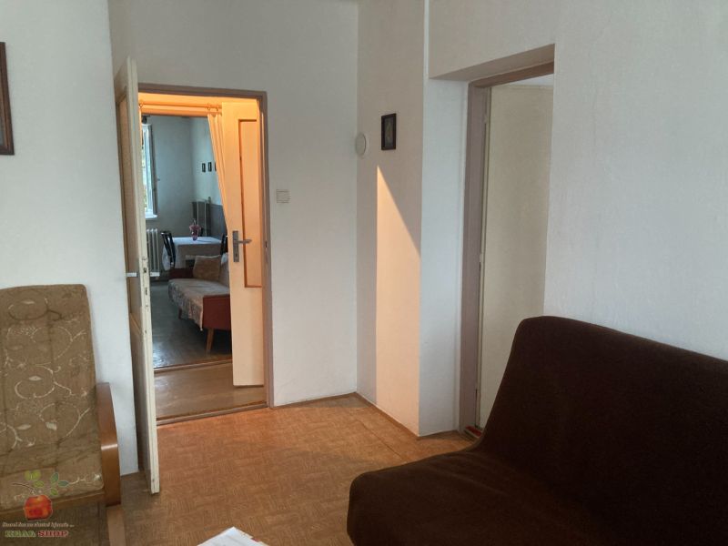 A room in a 3-room apartment with a view of the sofas and a wooden decor floor.