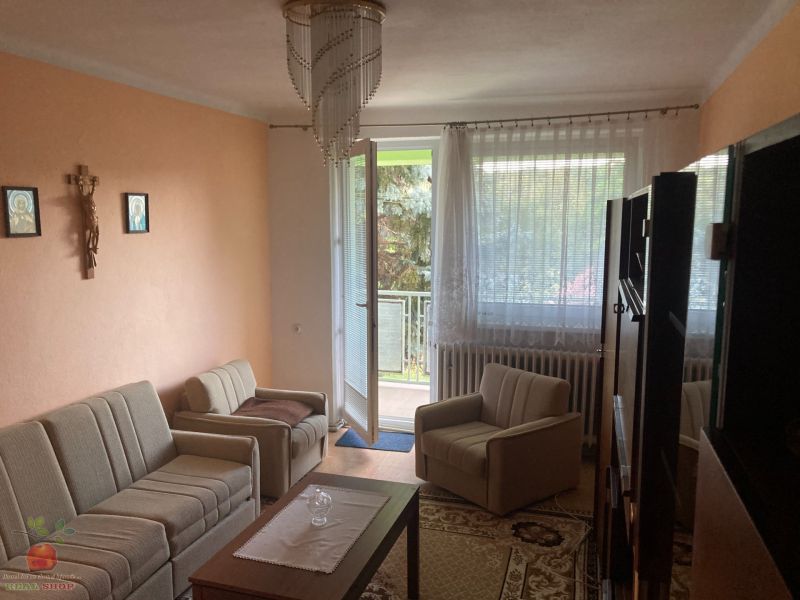 Living room in a 3-room apartment with comfortable seating and balcony doors.