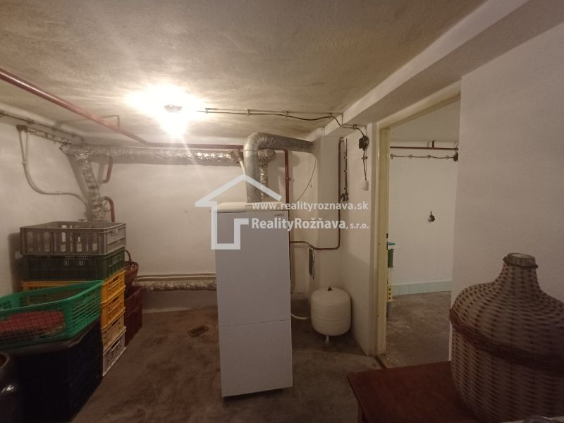 Basement storage in a family house with pipes and plastic crates.