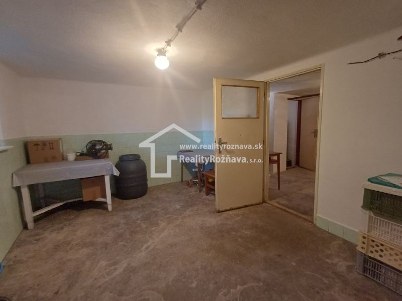 Interior of a family house with a bright room, a table, and storage containers.