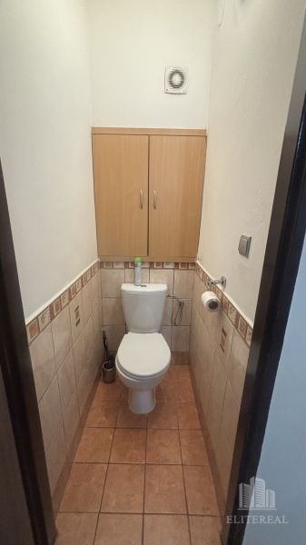 Small bathroom with a toilet and a cabinet in a 3-room apartment, tiles in beige shades.