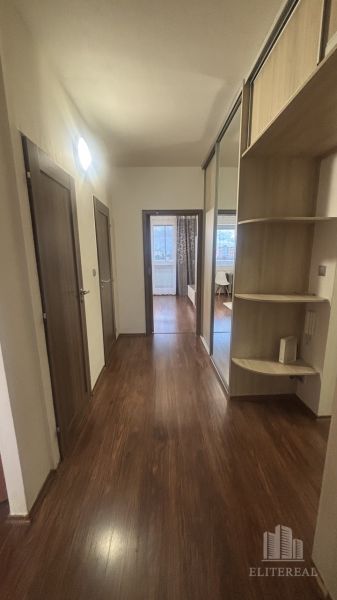 A hallway in a 3-room apartment with a wooden decor floor and a built-in wardrobe.