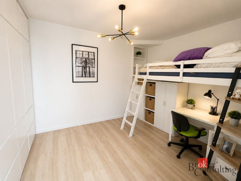 A one-room apartment with a raised bed, a desk, and flooring with a wooden decor.