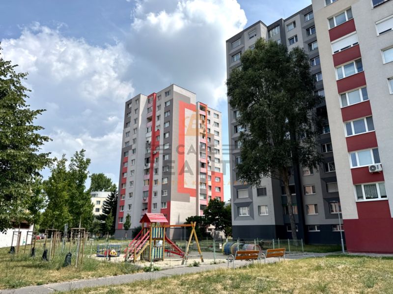 In Bratislava on Andrusovova Street, there are apartment buildings surrounded by a playground and greenery.