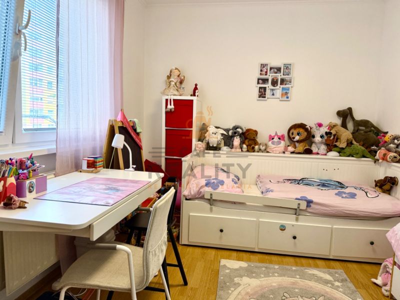 Children's room with wood-decor flooring, a desk, and toys in a 3-room apartment.