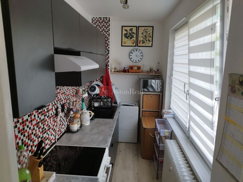 Cozy kitchen in a 2-room apartment with colorful tiles and a large window.