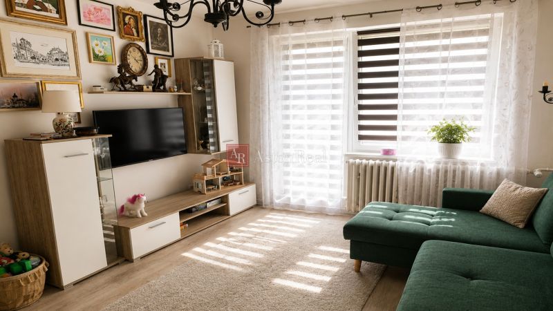 Living room in a two-room apartment with a sofa, decorations, and a wooden decor floor.