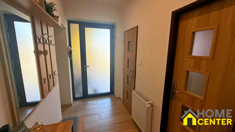 Entrance hallway in a family house with a wooden decor floor and a coat rack.