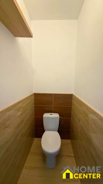 A toilet with wood decor tiles in a family house.