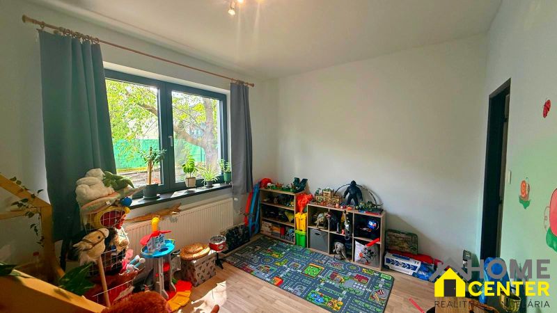 Children's room in a family house with a window and toys, floor with wooden decor.