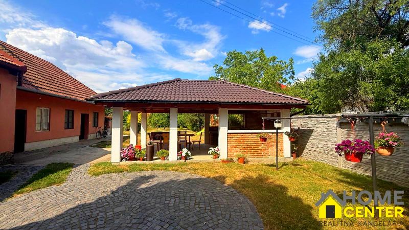 A garden in a family house in Iža with a gazebo and garden flowers in a brick design.