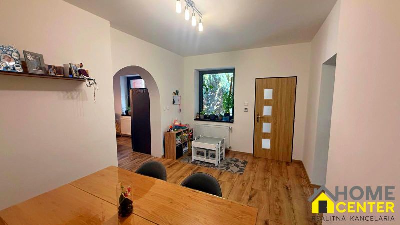 The interior of a family house with a wooden decor floor, light-colored walls, and a children's corner.