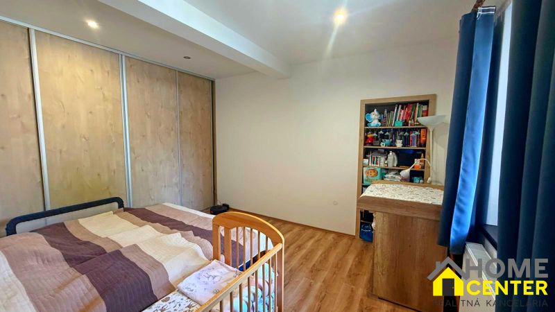 Children's room in a family house with a bed, wardrobes, and a wooden-decor floor.