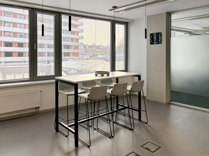 Glass table, high chairs, large windows, offices.