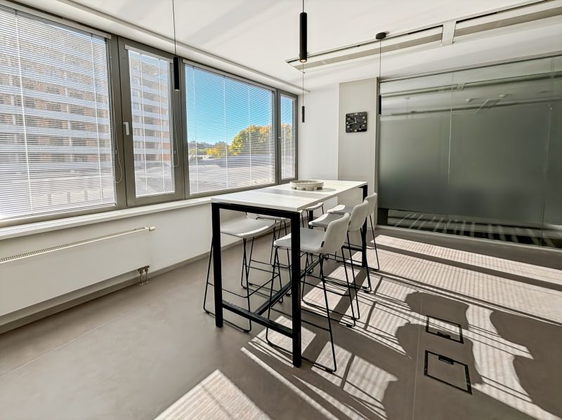Offices with large windows, a desk and chairs, interior with a glass wall.