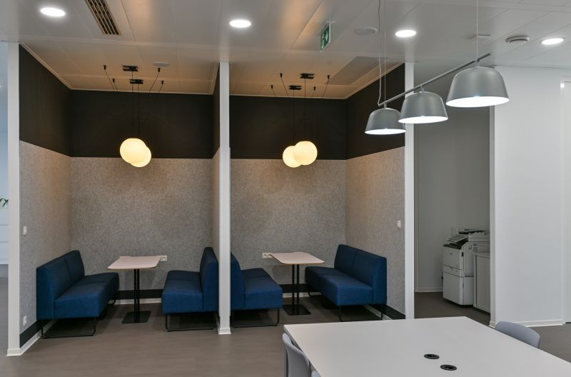 Offices with conference tables, blue sofas, and pendant lights for comfortable meetings.