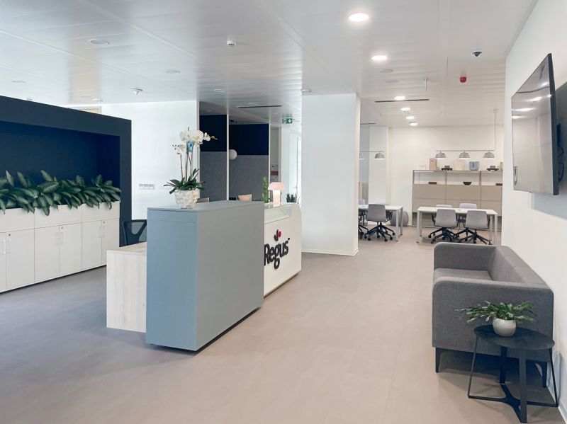 Reception in offices with wood-patterned flooring and minimalist seating.
