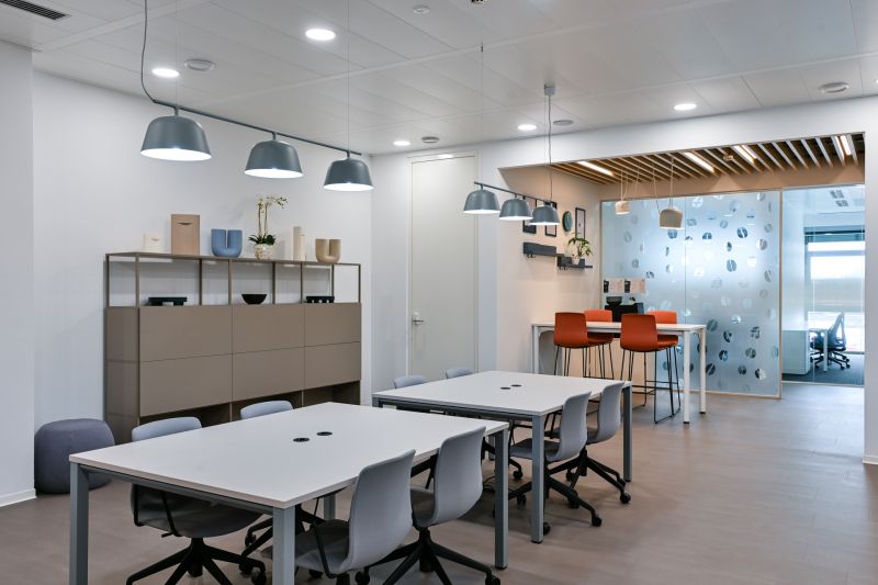 Offices with wood-patterned flooring, conference tables, and pendant lights.