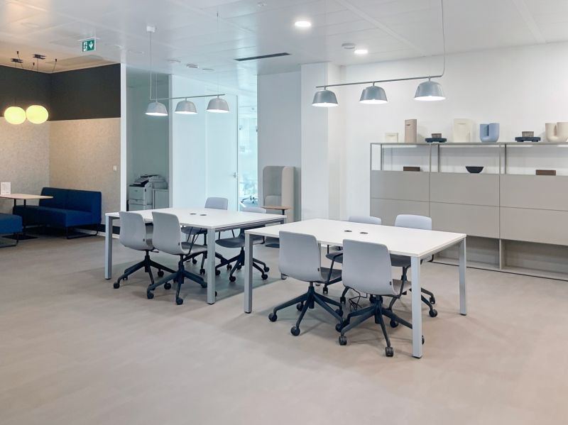 Offices with white desks, gray chairs, and a wooden-patterned floor.