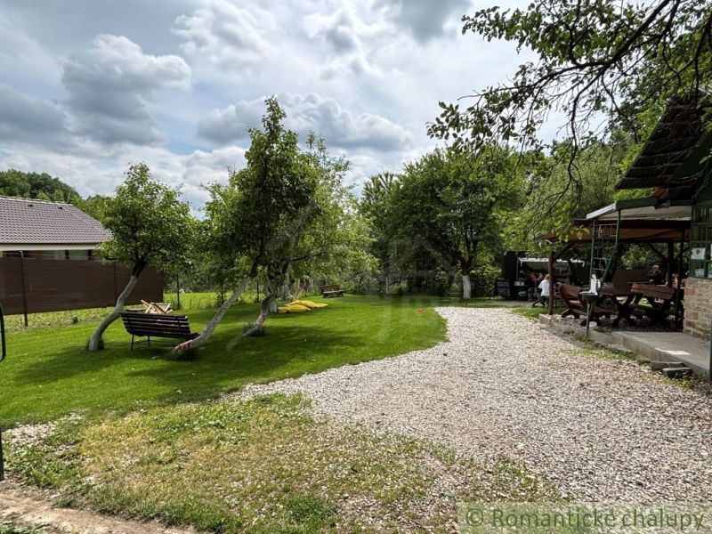 Garden by the cottage in Bratislava IV, with trees and seating area.